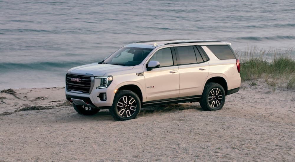 A white 2021 GMC Yukon AT4 is parked on a beach.
