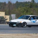 A white 1991 Honda CRX is shown driving past autocross cones.