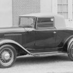 A black and white photo shows a 1932 Ford V8 from the side.