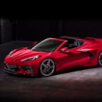 A red 2020 Chevy Corvette is shown from the side parked in a dark warehouse.