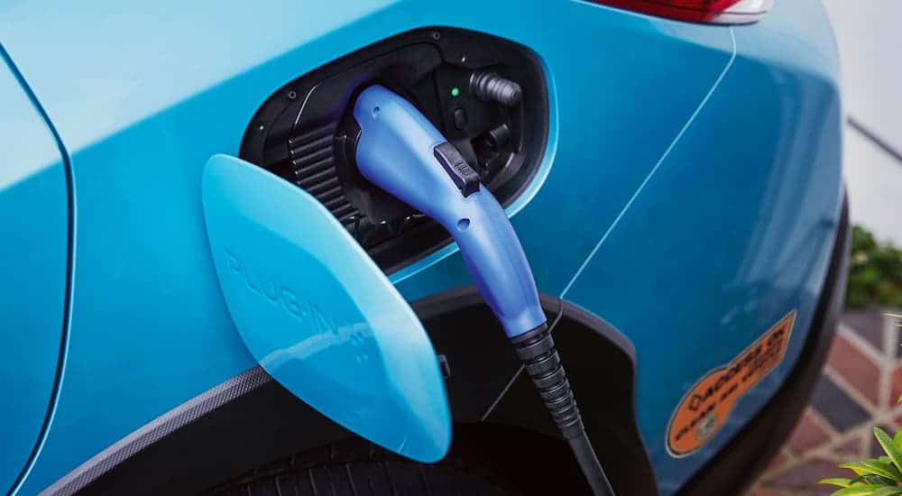 A close up shows a plug in the charging port of a blue 2021 Subaru Crosstrek Hybrid.