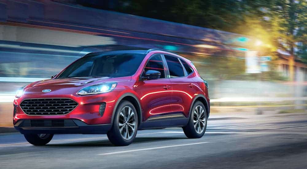 A red 2021 Ford Escape is driving past a colorful blurred background
