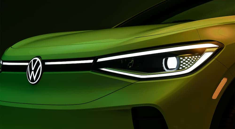 A close up shows the headlight and grill on a green 2021 Volkswagen ID.4.