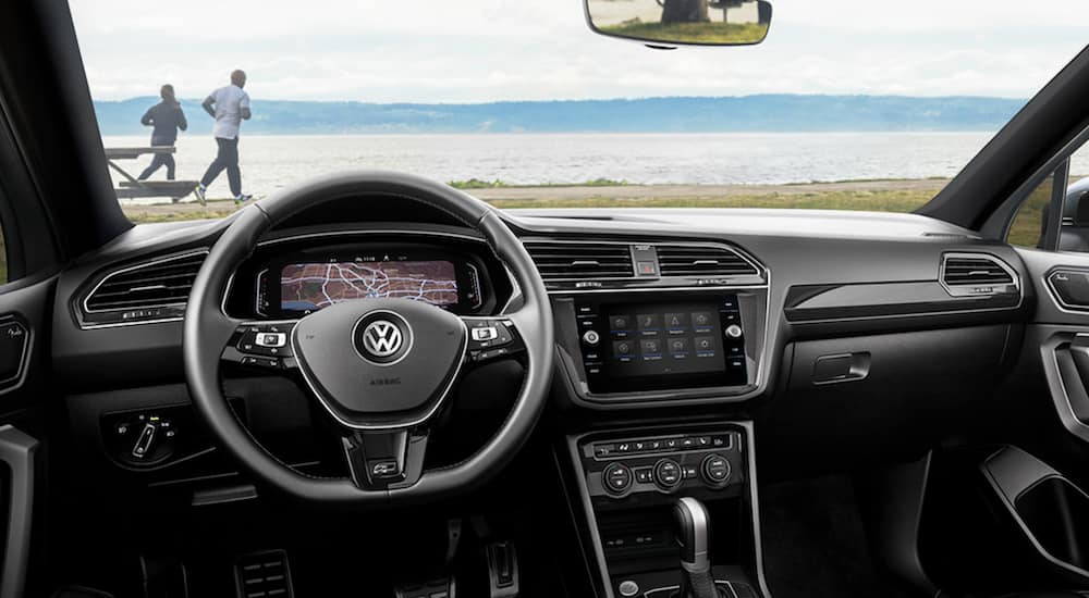 The interior of a 2021 Volkswagen Tiguan shows the steering wheel and infotainment screen.