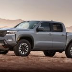 A grey 2022 Nissan Frontier is shown from the side parked in the desert.