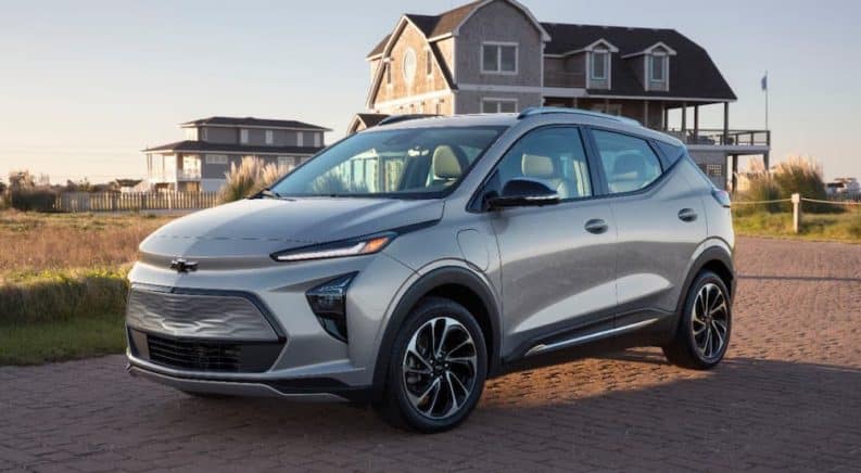 A silver 2022 Chevy Bolt EUV is parked in front of a beach house after leaving a Chevy dealer.