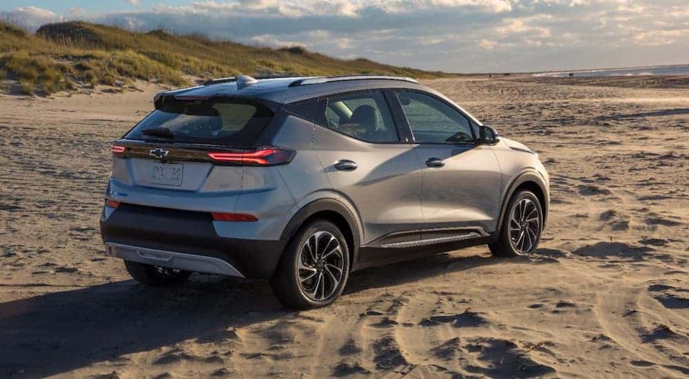 A silver 2022 Chevy Bolt EUV is parked on a beach and shown from a rear angle.
