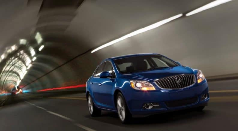 A blue 2014 Buick Verano Turbo is driving through a tunnel after leaving a used Buick dealership.