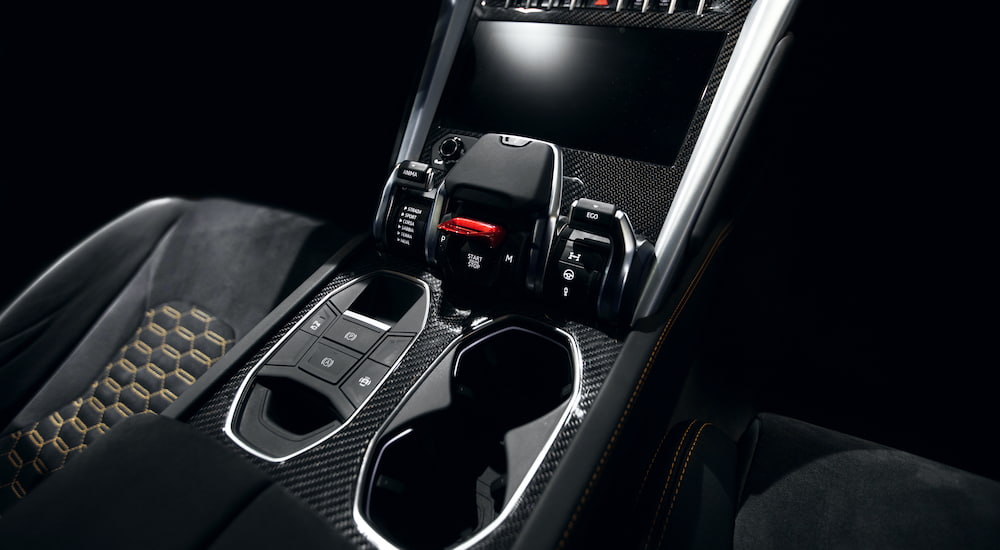 The interior of a supercar shows two front seats and infotainment screen.