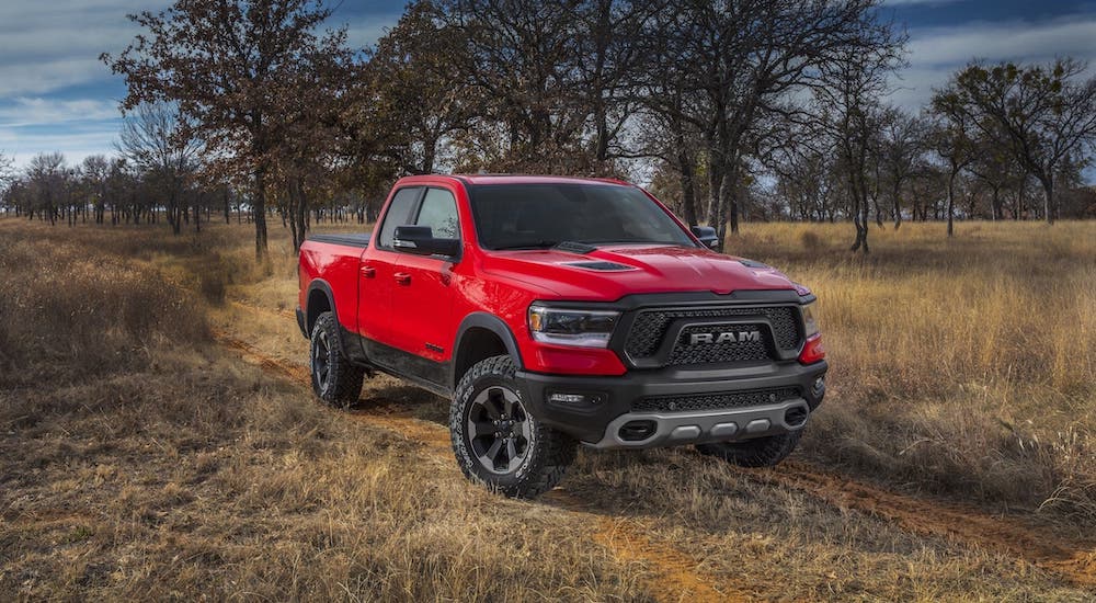 A red 2021 Ram 1500 Rebel is parked on a dirt trail after leaving a Ram 1500 Rebel dealer.
