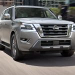 A silver The 2021 Nissan Armada is shown from the front driving through a city.