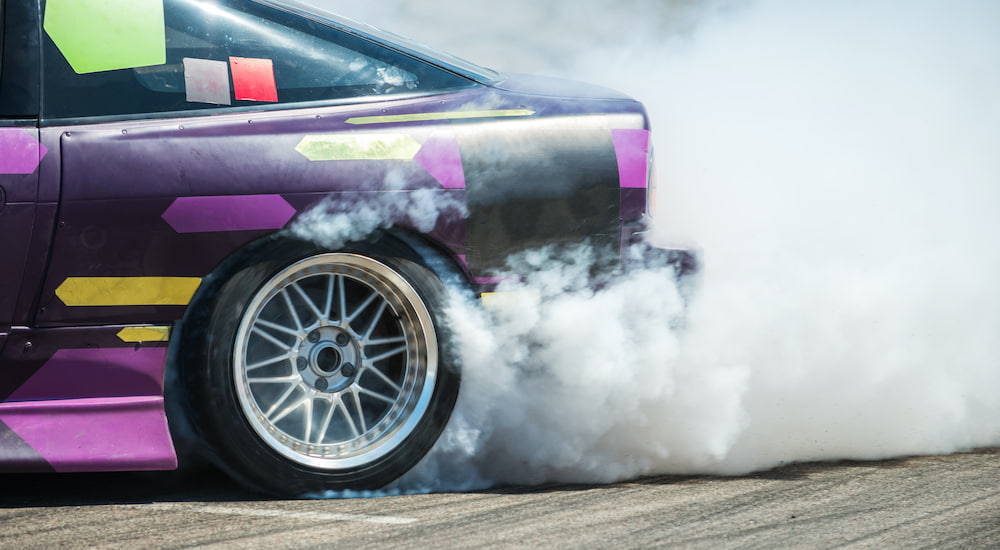 A modified car is doing a burn out.