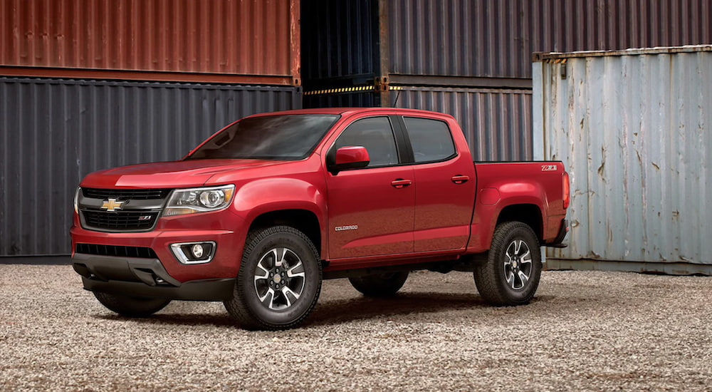 A red 2020 Chevy Colorado is parked outside of a barn. 