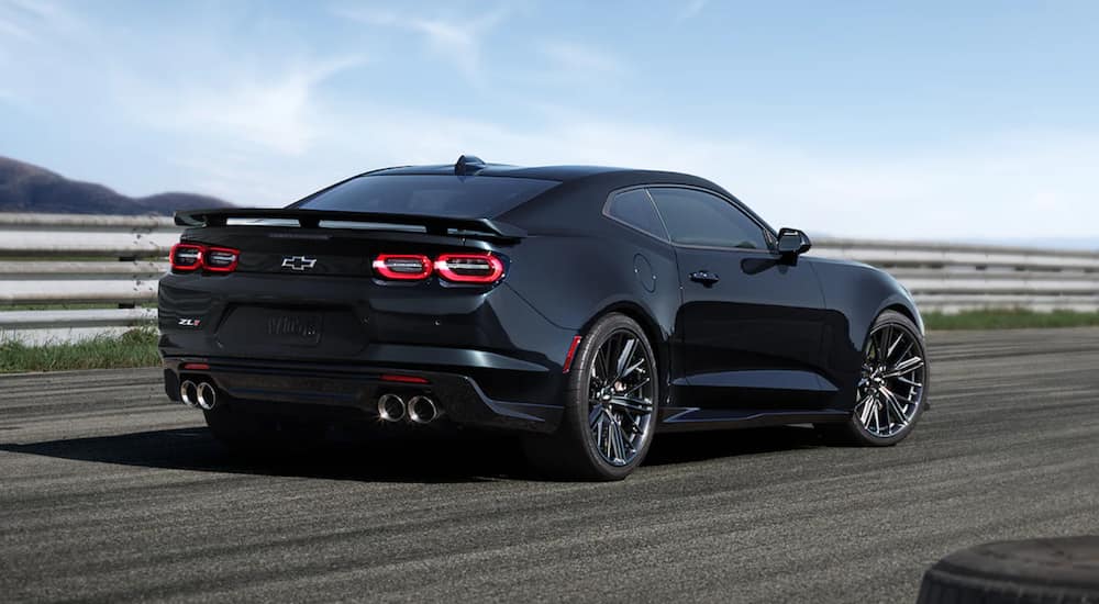 A black 2021 Chevy Camaro ZL1 is driving down a racetrack. 