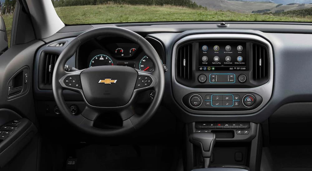 The interior of a 2021 Chevy Colorado shows the steering wheel and infotainment screen.