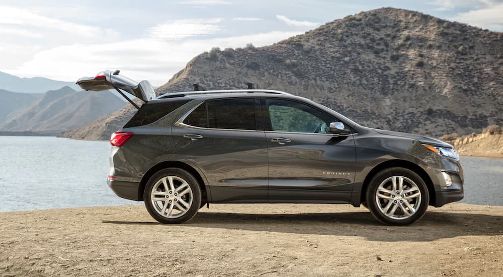 A silver 2021 Chevy Equinox is parked in front of a lake with the lift gate open.