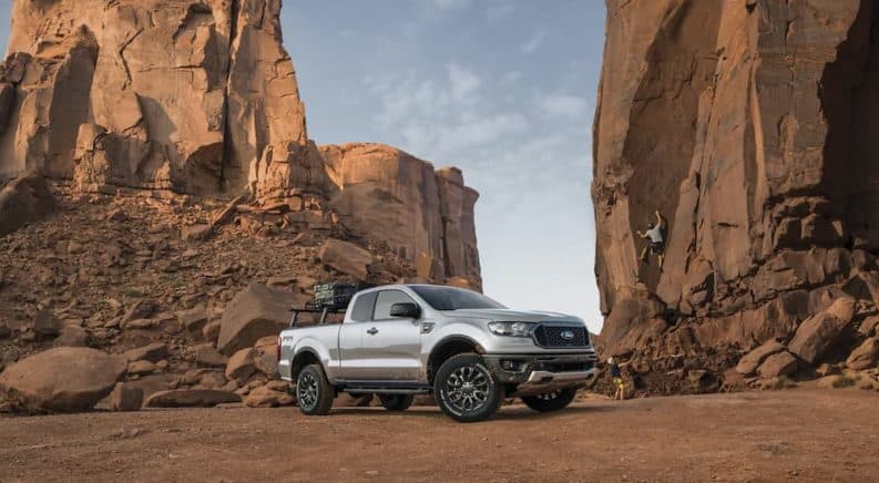 A silver 2021 Ford Ranger is parked in the desert in front of rocks.