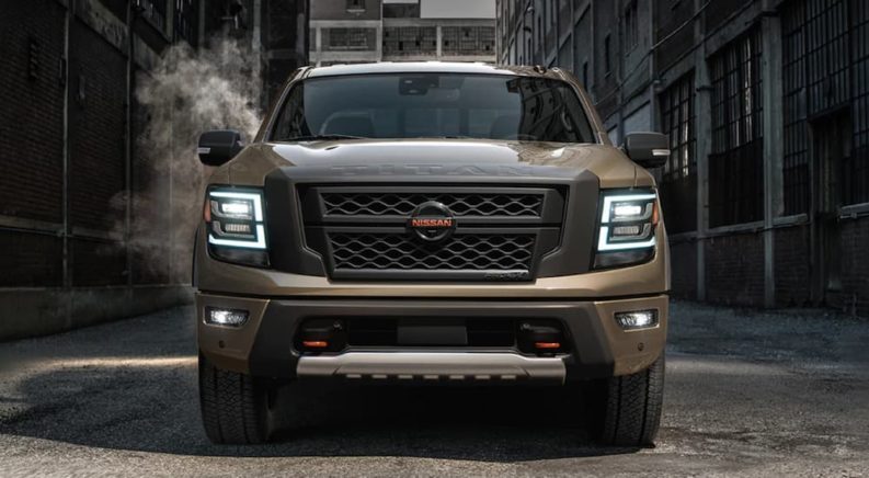 The front of a tan 2021 Nissan Titan XD is shown in an alley.