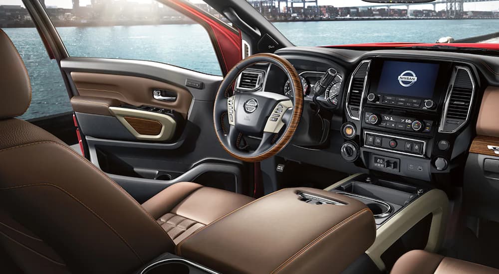 The interior of a 2021 Nissan Titan XD shows the steering wheel and infotainment system.