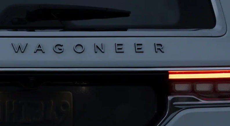 The emblem of a white 2022 Wagoneer is shown at dusk.
