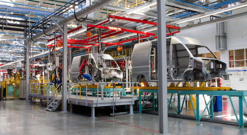 Vans are being assembled on a production line at a modern plant.