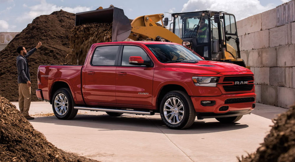 A red 2021 RAM 1500 is being used at a construction site.