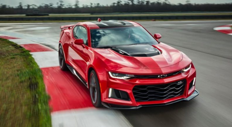 A red 2017 Chevy Camaro ZL1 is shown driving on a race track.