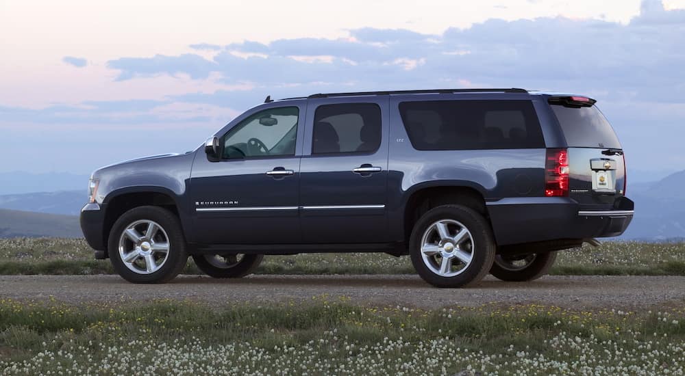 A black 2009 Chevy Suburban is parked in a field at sunset.