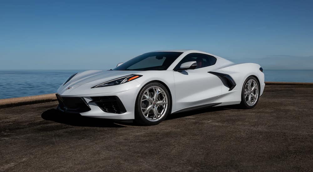 A white 2021 Chevy Corvette is parked next to the ocean after leaving a Chevy dealership in Alabama.
