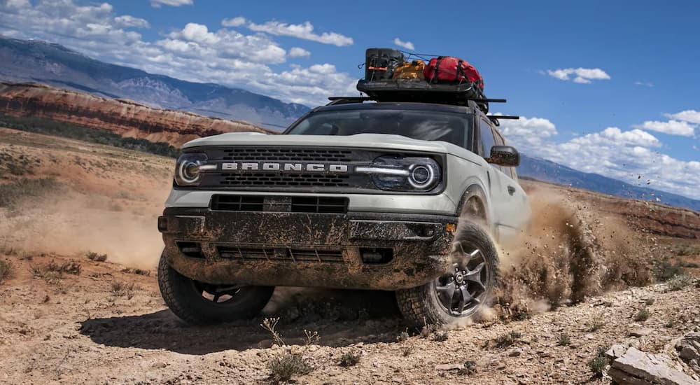 A silver 2021 Ford Bronco is off-roading in the desert.