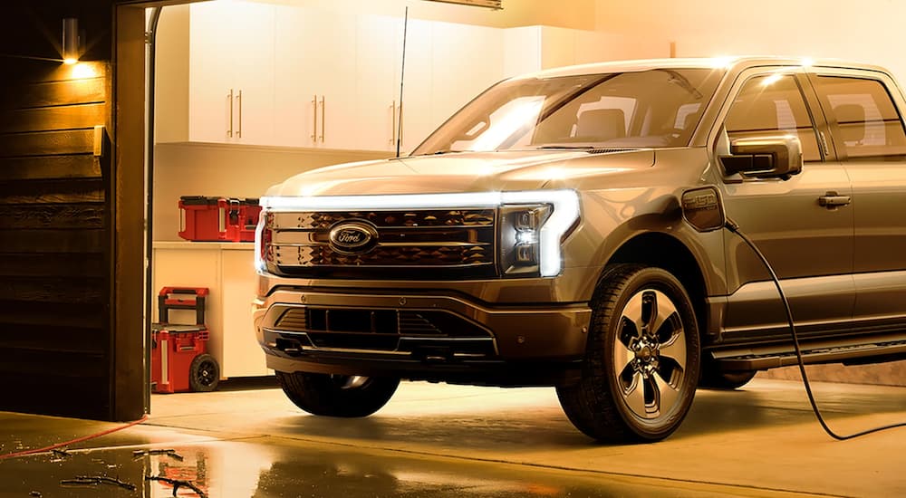 A 2022 Ford F-150 Lightning is charging in a garage.
