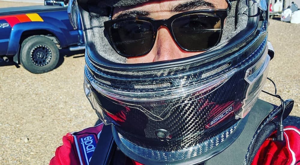 A close up shows Dave with sunglasses and a carbon fiber helmet.