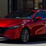 A red 2021 Mazda3 is shown parked on a city street after leaving a Mazda3 dealer.