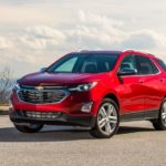 A red 2020 Chevy Equinox is parked on cement overlooking a mountain view after leaving a used Chevy dealership.