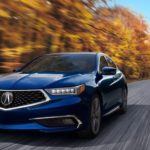 A blue 2020 Acura TLX is shown driving from the front.