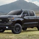 A black 2021 Chevy Silverado 1500 Z71 Trailboss is parked in a field in front of mountains after winning a 2021 Chevy Silverado 1500 vs 2021 GMC Sierra 1500 comparison.