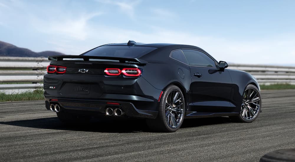 A black 2021 Chevy Camaro ZL1 is shown driving on a racetrack.