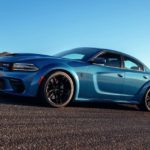 A blue 2021 Dodge Charger is driving on a runway after winning a 2021 Dodge Charger vs 2021 Chevy Camaro comparison.
