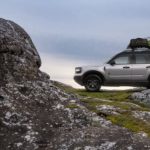 A silver 2021 Ford Bronco Sport is parked on rocks in the mountains.