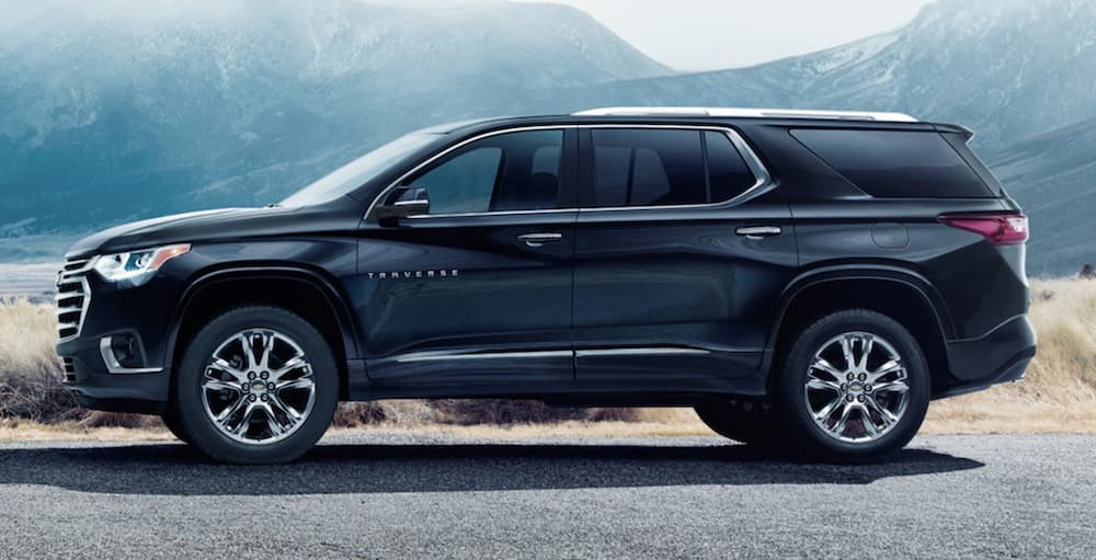 A black 2021 Chevy Traverse is shown from the side parked in front of a mountain.