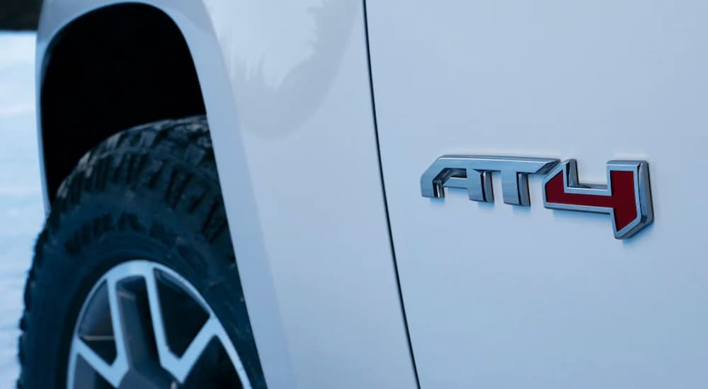 A white 2021 GMC Canyon shows a close up of the AT4 logo.
