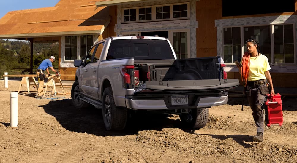 A silver 2022 Ford F-150 Lightning is being used at a construction site.