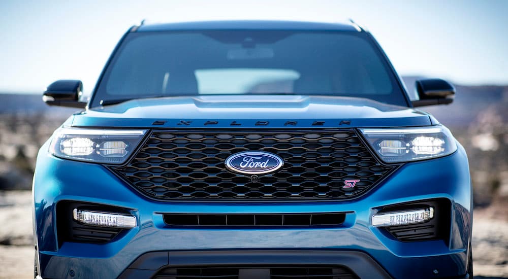 A close up shows the grille and headlights of a blue 2021 Ford Explorer ST, one of the most popular Ford pre-owned cars.