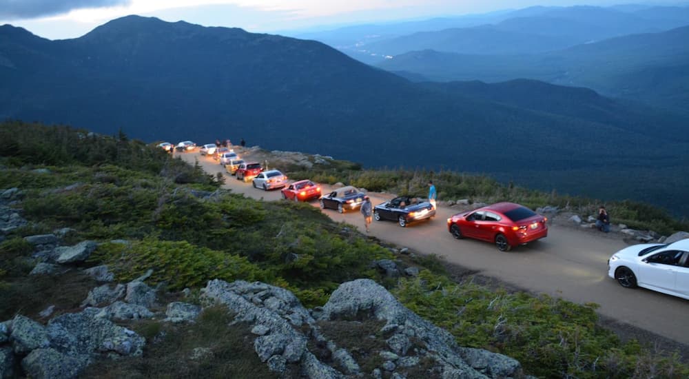 A line of Mazda cars are shown driving down Mount Washington. 