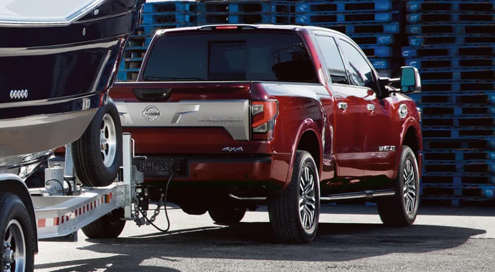 A red 2021 Nissan Titan XD is towing a boat.