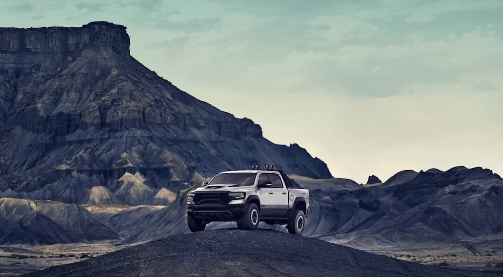 A silver 2021 Ram TRX is parked on top of a sand hill.