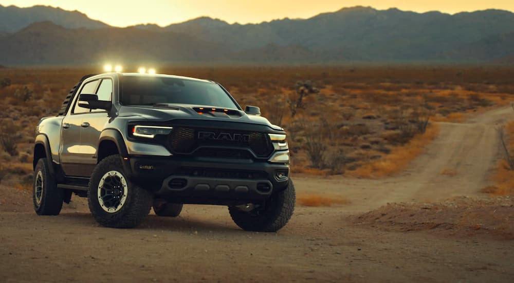 A black 2021 Ram 1500 TRX is shown with the light bar illuminated next to a dirt path.
