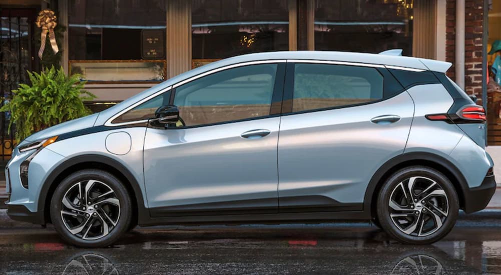 A blue 2022 Chevy Bolt EV is shown from the side after leaving an electric car dealer.
