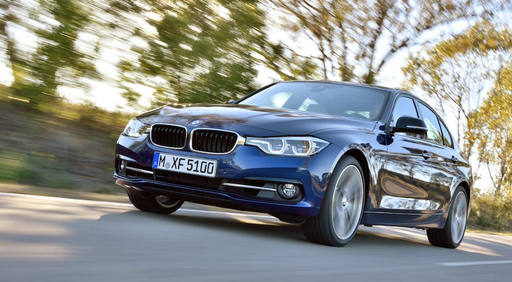 A blue 2015 BMW 3 Series is shown from a low angle.