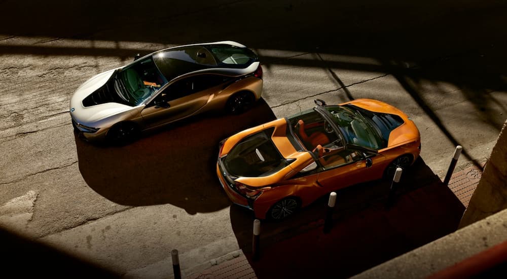 A silver 2020 BMW i8 coupe and an orange i8 convertible are shown from above.